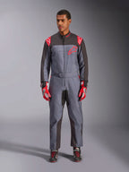 Mono Alpinestars KMX-9 V3 Graphic 6, mono de karting, negro antracita y rojo, patrón gráfico con motas grises, paneles negros en la parte interna de brazos y piernas, logotipos Alpinestars rojos en hombros y pecho, usado con guantes de carreras rojos y calzado negro