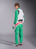 Alpinestars KMX-9 V3 Graphic 6, mono de karting, blanco, verde y rojo, modelo visto desde la parte posterior, con mangas y paneles inferiores verdes, parte superior del torso blanca con detalles de motas negras, llamativo logotipo de Alpinestars en rojo en la zona lumbar, combinado con calzado de karting a juego en blanco y verde