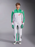 Alpinestars KMX-9 V3 Graphic 6 Suit, blanco, verde y rojo, mono de karting de una pieza con un patrón gráfico de salpicaduras negras, paneles verdes en las mangas y las piernas, logotipo rojo de Alpinestars en el pecho, usado con guantes y calzado de competición a juego