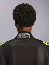 Alpinestars GP Race V3 Suit FIA, negro y amarillo flúor, primer plano de la parte posterior del cuello con la etiqueta de certificación FIA 8856-2018, traje de automovilismo profesional