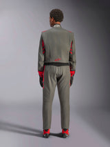 Rear view of a model wearing the Alpinestars GP Race V3 Suit in Anthracite Red, professional auto racing suit with red accents on the sleeves and legs, paired with red racing boots and black gloves, technical motorsport apparel shown in a studio setting.