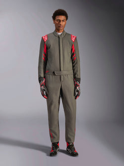 Alpinestars GP Race V3 Suit FIA, mono de automovilismo, color antracita y rojo, usado por un modelo masculino con guantes y botas a juego, con hombreras rojas y logotipos de la marca, equipamiento profesional de automovilismo para conducción de alto rendimiento