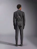Mono Alpinestars Hypertech V3, Black Dark Shadow, vista posterior de un mono de automovilismo profesional de una pieza, con etiqueta de certificación FIA en el cuello y logotipos 'Alpinestars' y 'RACING AHEAD' en la parte inferior de la espalda, usado con guantes y botas de competición negros a juego.