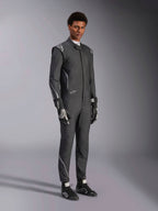 Mono Alpinestars Hypertech V3, traje de automovilismo, negro y Dark Shadow, usado por un modelo masculino con guantes y calzado de competición negros a juego, corte atlético ajustado, incluye logotipos de Alpinestars y detalles en gris claro, equipamiento de protección profesional para automovilismo.