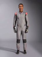 Mono Alpinestars Hypertech V3, traje de carreras profesional en gris medio, negro y rojo flúor, vestido por un modelo con guantes y calzado de competición negros, con un corte atlético ajustado, detalles en rojo flúor en los hombros y paneles negros en las rodillas y laterales.