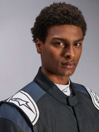 Traje Alpinestars GP Pro Comp V2 FIA, traje de carreras de auto para hombre, negro y asfalto con hombreras blancas.
