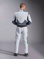 Alpinestars GP Pro Comp V2 FIA, traje de automovilismo gris y negro, vista trasera con certificación FIA y paneles elásticos.