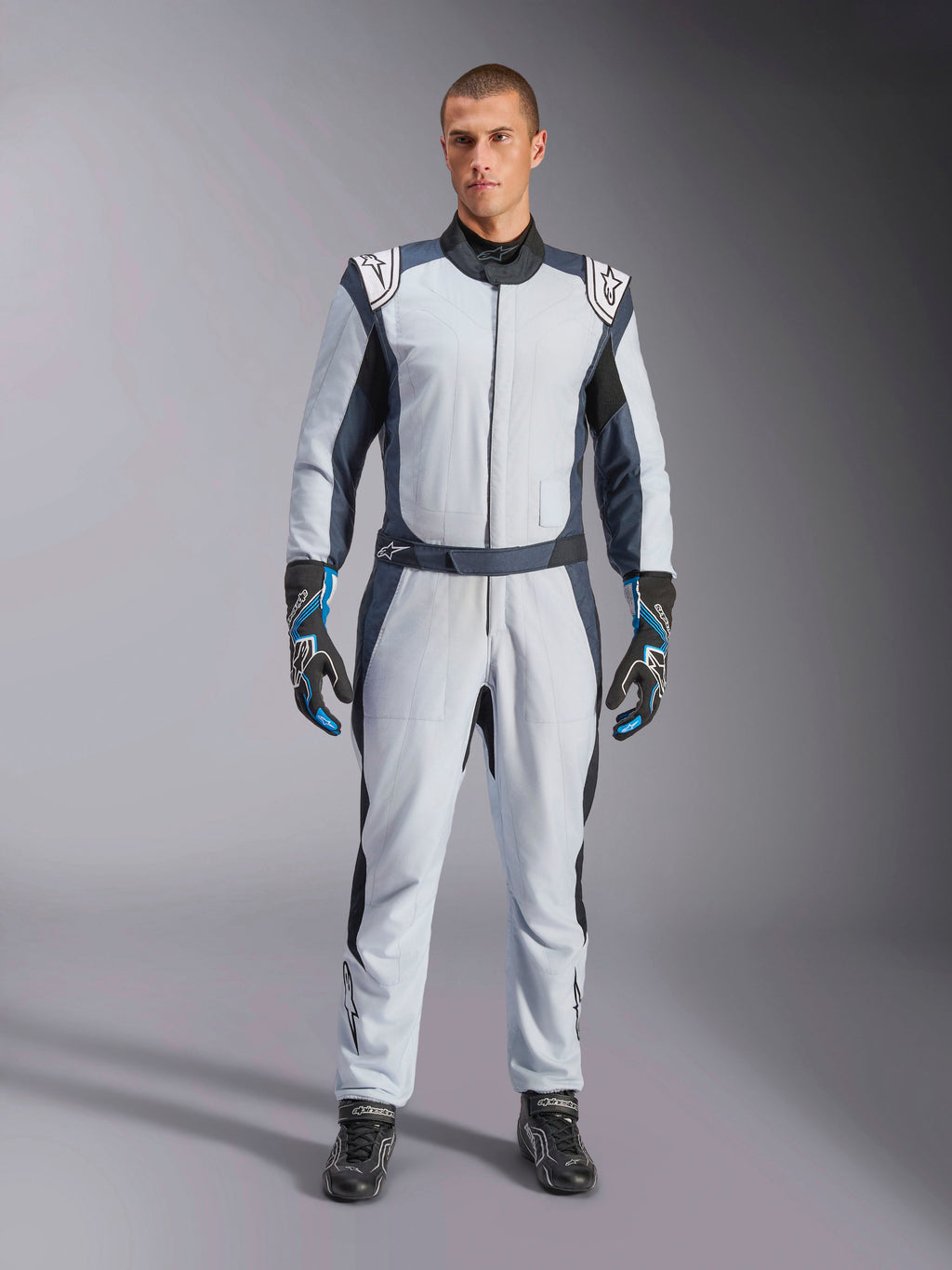 Alpinestars GP Pro Comp V2 FIA, traje de automovilismo para hombre, plateado, azul y asfalto, diseño de aramida con certificación FIA, visto en modelo.