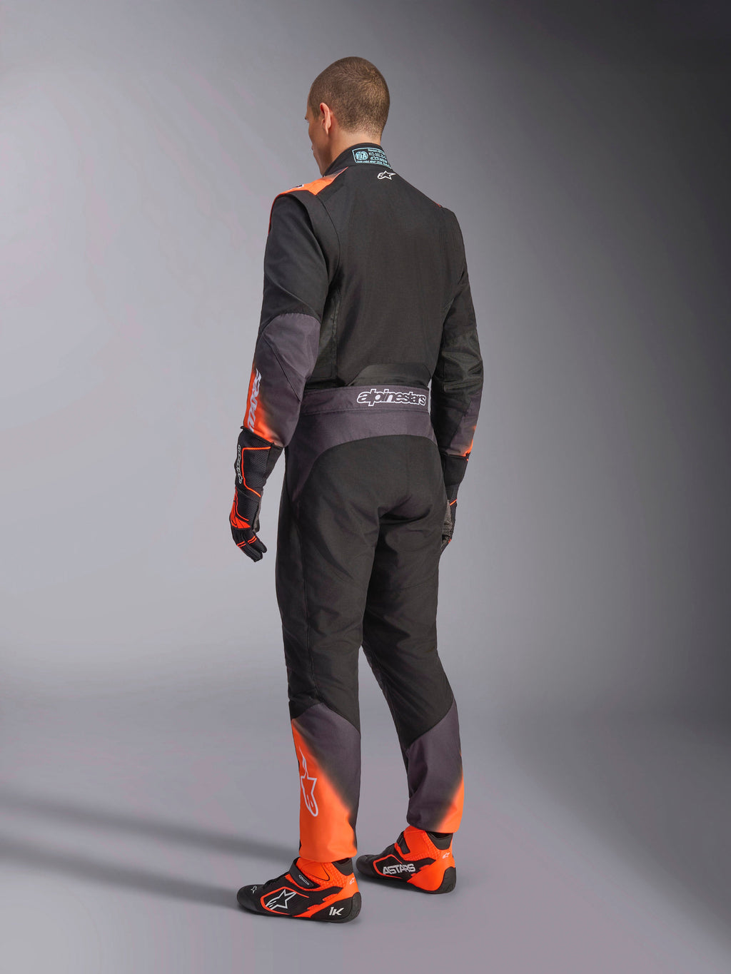 Alpinestars Traje KMX-5 V3 para karting, hombre, vista posterior, negro y naranja flúor, certificado FIA 8877-2022 Grado 1