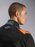 Traje Alpinestars KMX-5 V3, traje de karting para hombre, negro y naranja flúor, certificado FIA 8877-2022 Grado 1, con paneles de malla técnica transpirable y logotipo blanco.