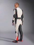 Mono Alpinestars GP Tech V4, traje de carreras en blanco, negro y rojo, vista trasera que muestra paneles elásticos ergonómicos en la zona lumbar y las piernas, combinado con guantes y calzado de competición a juego, equipamiento profesional para automovilismo.