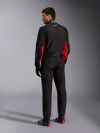 Mono Alpinestars KMX-9 V3, negro, rojo y blanco, mono de karting de una pieza visto desde atrás, con costuras geométricas blancas en la espalda y detalles rojos en las mangas, usado con guantes de carreras negros y botas de karting