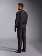 Mono Alpinestars KMX-9 V3 Graphic 3, negro y rojo, vista trasera de un modelo con equipamiento completo de karting que incluye guantes negros y botas de competición, con paneles laterales rojos y detalles del logo en blanco
