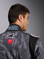 Alpinestars KMX-9 V3 Graphic 5 Suit, mono de karting, patrón de camuflaje en gris oscuro y negro, primer plano de la parte superior de la espalda con el logotipo de Alpinestars, etiqueta roja de la marca y etiqueta de homologación FIA en el cuello