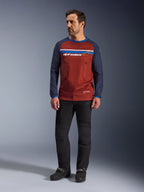 Alpinestars Maxdura Dual Jersey, marrón óxido y azul Mood Indigo, jersey de motociclismo de aventura con torso de malla y mangas azul marino, usado por un modelo con pantalones de motociclismo negros y botas negras, equipamiento técnico dual-sport para conducción fuera de carretera