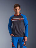 Hombre vistiendo Alpinestars Maxdura Dual Jersey en gris oscuro y azul real con detalles naranjas, con torso de malla completa y bolsillos con cremallera en el pecho, combinado con pantalones de aventura azules a juego, ropa técnica para dual-sport y off-road