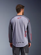Jersey Alpinestars Maxdura Dual, vista trasera, en color gris medio y gris oscuro, con espalda de malla transpirable con logotipos de la estrella de Alpinestars en rojo, manga larga y dobladillo trasero extendido, equipamiento para motociclismo de aventura