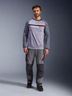 Alpinestars Maxdura Dual Jersey, gris medio y gris oscuro, jersey de motociclismo de aventura con torso de malla y bolsillos en el pecho con cremallera, mangas resistentes a la abrasión con acolchado integrado, combinado con pantalones técnicos grises a juego con detalles en rojo, equipamiento técnico de conducción off-road