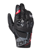 Alpinestars Belize V3 Drystar, guantes de moto para aventura con puño corto, negros con detalles en rojo y gris, con protección rígida de nudillos con patrón hexagonal, paneles de cuero perforado y logotipo 'ADVENTURE' en la muñeca.