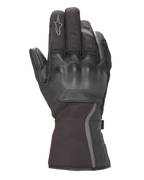 Alpinestars Stella Tourer W-7 Drystar® Gloves, guantes para mujer, negros, vista del dorso con protección de nudillos rígida recubierta de cuero, puño largo de turismo con ribete reflectante, logotipo Alpinestars en el dedo índice, confeccionados en tejido impermeable y cuero.