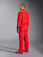 Alpinestars Kart Indoor V2 Suit, mono de karting rojo, vista trasera de tres cuartos en un modelo, usado con guantes rojos y calzado de competición a juego, construcción de sarga de poliéster y algodón de una sola capa, equipamiento profesional para karting en interiores