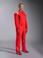 Mono Alpinestars Kart Indoor V2, mono de karting rojo, usado por un modelo con guantes y calzado rojos y negros a juego, con logotipos blancos en los hombros y la parte inferior de la pierna, detalles en negro, diseñado para karting recreativo y pistas de interior