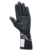 Guantes Alpinestars Tech-1 Start V4 FIA, guante de automovilismo negro, vista de la palma con patrones de agarre de silicona gris en los dedos y la palma, logotipo Astars blanco en el puño extendido, etiqueta de certificación FIA, equipo profesional de automovilismo