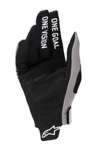 Guantes Alpinestars Radar Pro 2025, guantes de motocross, negros con detalles en gris, vista de la palma con la inscripción 'ONE GOAL ONE VISION' impresa en los dedos, material de gamuza sintética, diseño minimalista para rendimiento off-road