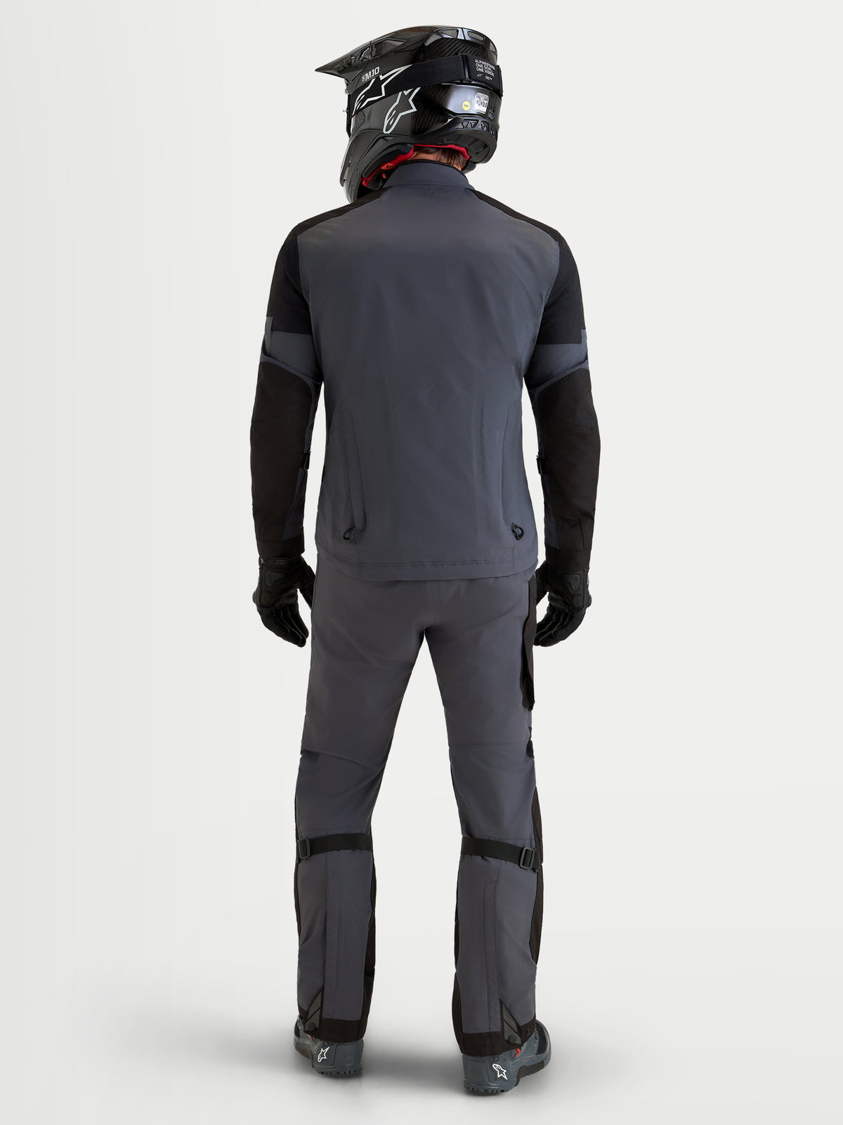 Alpinestars Arenis Gore-Tex Chaqueta, chaqueta de moto de aventura para hombre en negro y gris oscuro, vista trasera en modelo que muestra la construcción textil impermeable y los pantalones de equitación a juego