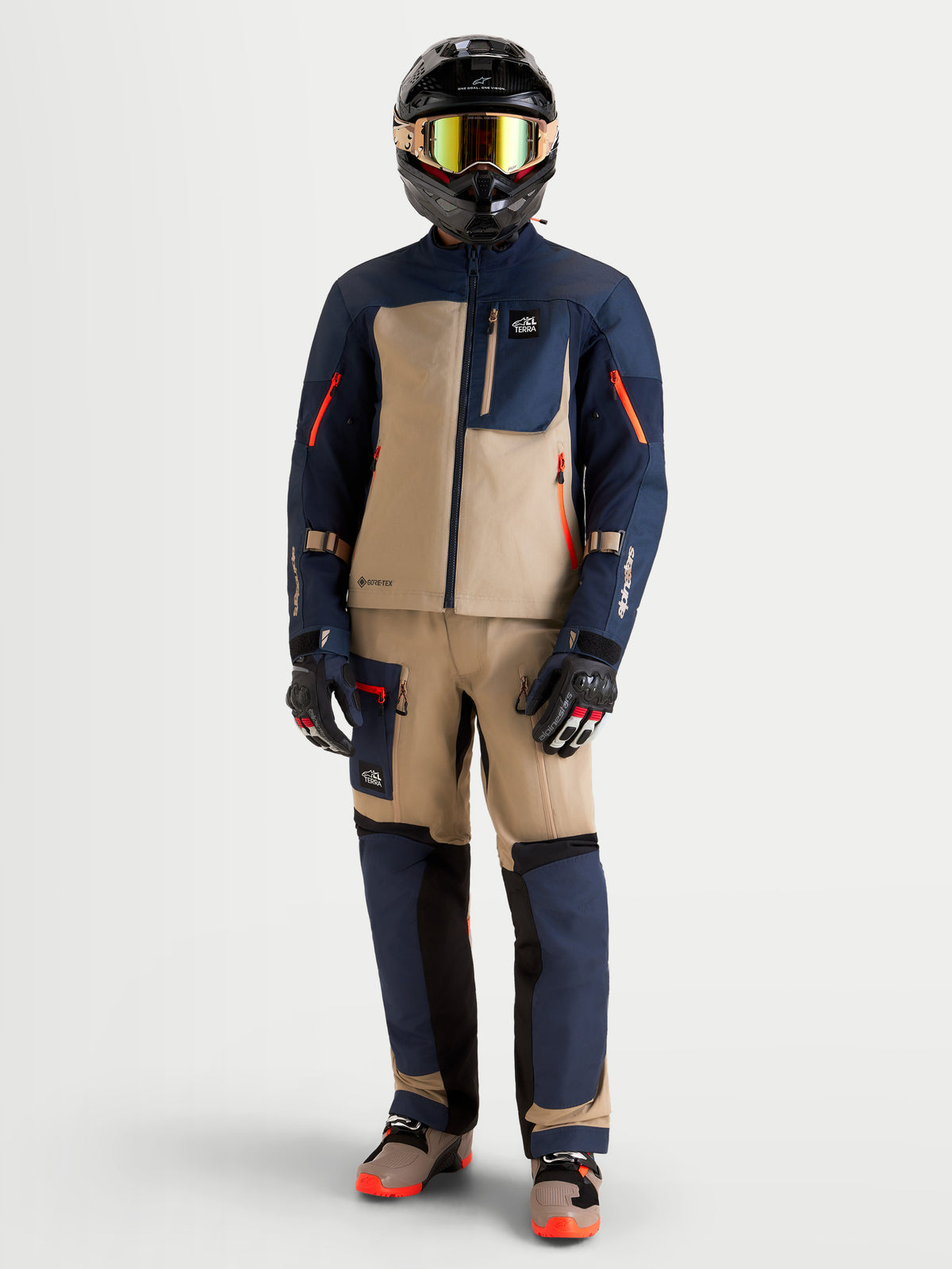 Alpinestars Arenis Gore-Tex Jacket, men's adventure touring motorcycle jacket in night navy blue and aluminum beige, worn by a rider with matching ADV gear and helmet.