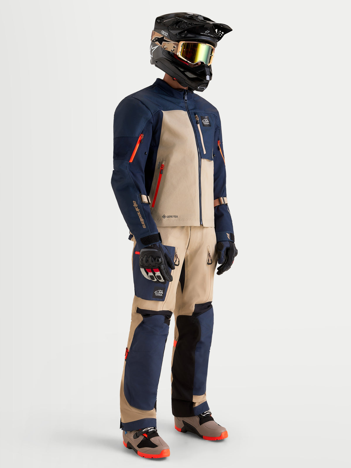 Alpinestars Arenis Gore-Tex Gear Set, conjunto de aventura para moto de hombre en azul marino y aluminio, vista de perfil completo en modelo con equipamiento y casco a juego, con certificación AA e impermeabilidad