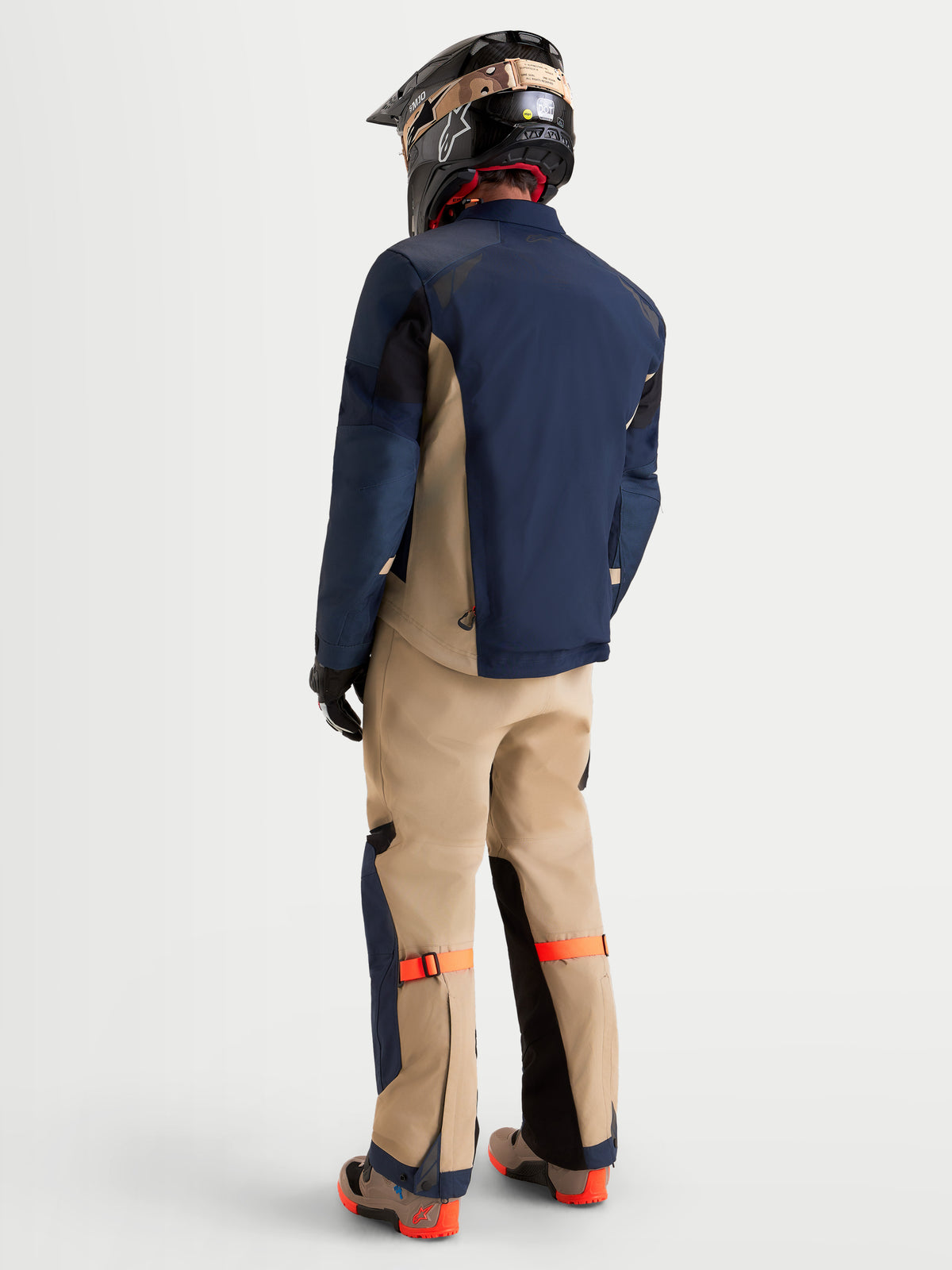 Alpinestars Arenis Gore-Tex Gear Set, equipo de aventura para moto de hombre en azul marino y beige, vista trasera en un modelo con equipamiento y casco a juego, construcción textil impermeable para conducción todoterreno