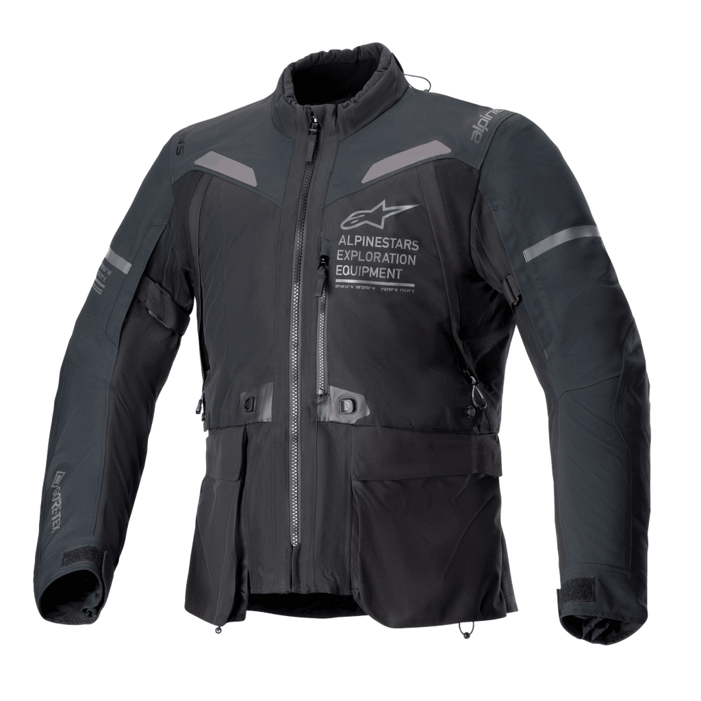 Chaqueta Alpinestars ST-7 2L GORE-TEX, chaqueta de moto en color negro y gris oscuro, vista frontal con grandes bolsillos cargo, detalles reflectantes en los hombros y logotipo Alpinestars Exploration Equipment en el pecho, equipamiento de touring de aventura impermeable