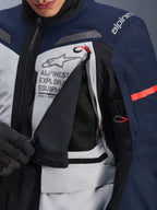 Alpinestars ST-7 2L GORE-TEX Jacket, Adventure Touring Jacket, Ice Gray Dark Blue and Black, detailed view of the unzipped chest ventilation panel revealing black mesh, featuring Alpinestars Exploration Equipment logo and red accent pull tabs