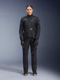 Female rider wearing Alpinestars Women Stella ST-7 2L GORE-TEX Jacket and Pants, Black motorcycle touring outfit, waterproof and breathable technical gear, worn with matching black gloves and boots, full-body protective gear with reflective elements, modern technical design for adventure riding