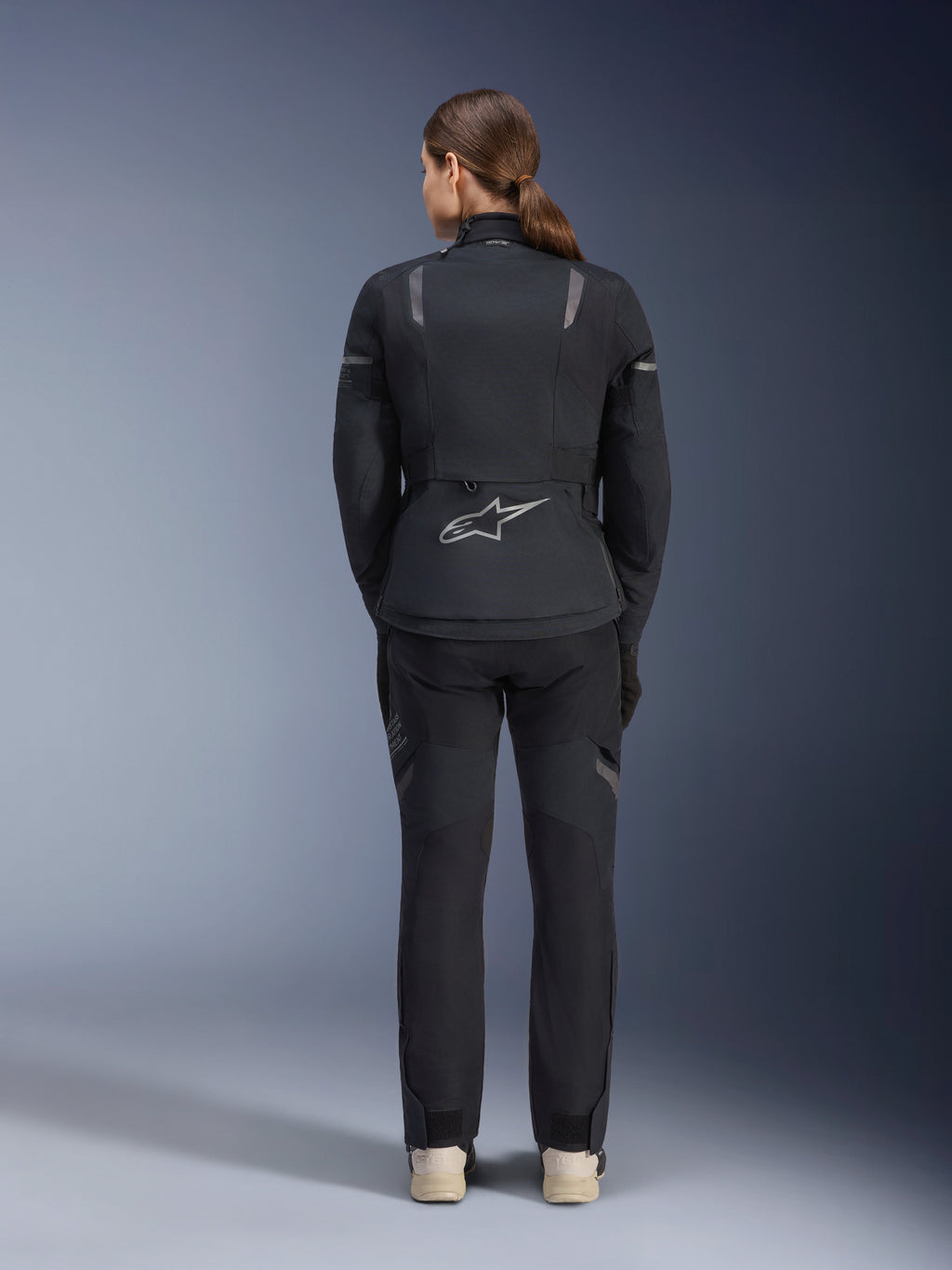 Alpinestars Women Stella ST-7 2L GORE-TEX Jacket, Black and Dark Gray, back view featuring the silver Alpinestars logo on the lower back, paired with matching black textile pants, adventure touring motorcycle gear