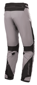 Pantalones Alpinestars Road Pro GORE-TEX, pantalones de moto touring, gris oscuro y negro, vista trasera con confección en tejido técnico, refuerzos de nailon balístico negro, correas ajustables en las rodillas y los tobillos, y logotipo de Alpinestars.