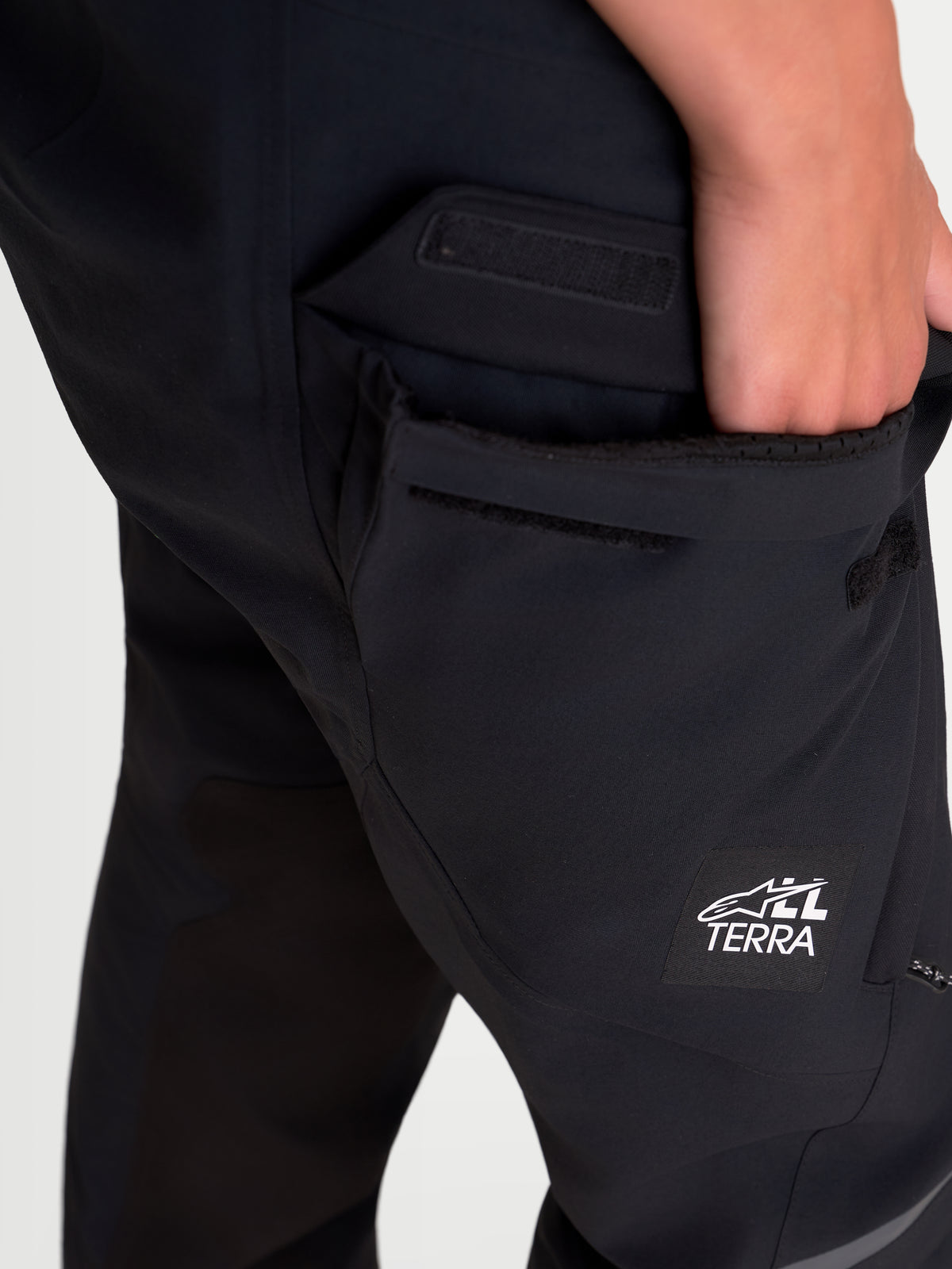 Alpinestars Stella ST-7 V2 2L Gore-Tex Pants, women's adventure touring motorcycle pants, black, detailed close-up showing waterproof cargo pocket and All Terra logo branding on a model.