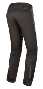 Pantalones Alpinestars Stella Road Pro GORE-TEX para mujer, negros, vista trasera de tres cuartos, pantalones técnicos de moto con marca Alpinestars reflectante en la parte inferior de la pierna, con ajuste cónico, ajustadores de velcro y cremallera de conexión en la cintura para touring de aventura