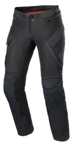 Alpinestars Women Stella ST-7 2L GORE-TEX Pants, Adventure Touring Motorcycle Pants, Black and Dark Gray, front view featuring cargo pockets, magnetic waist buckle, articulated knees with armor positioning, and subtle Alpinestars branding on the thigh.