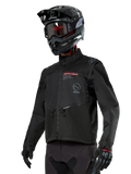 Chaqueta Alpinestars Pro-Dura, chaqueta de moto off-road, negra con logotipos rojos y grises, cuenta con bolsillos frontales con cremallera y cuello alto, usada con casco de motocross y guantes negros para carreras de enduro