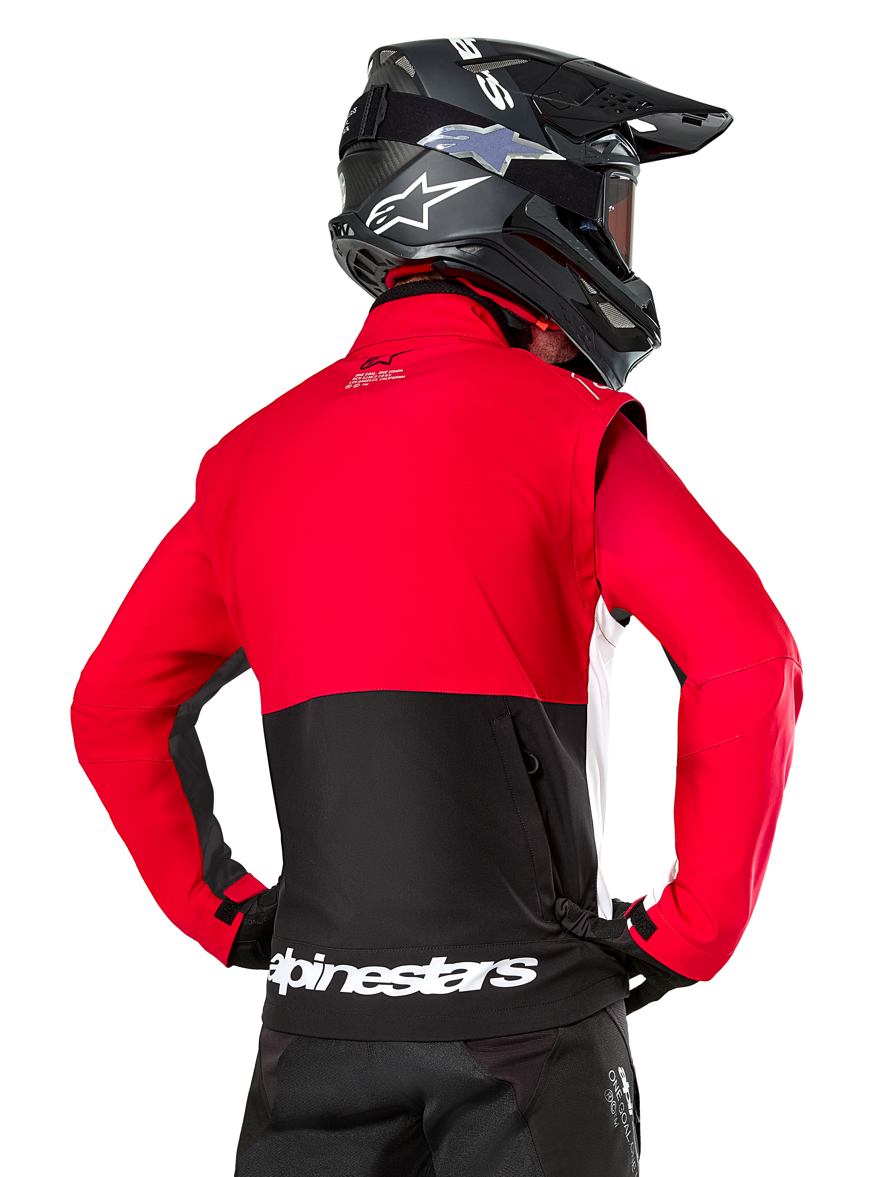 Chaqueta Alpinestars Pro-Dura, chaqueta de enduro off-road, roja y negra con logotipo de Alpinestars en blanco en el dobladillo trasero, vista desde atrás de un piloto con casco de motocross negro, diseño inspirado en el rally para conducción agresiva en senderos