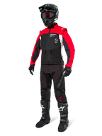 Chaqueta Alpinestars Pro-Dura, chaqueta de motociclismo todoterreno, negro, rojo brillante y blanco, usada con equipamiento completo de carreras que incluye casco negro con gafas rojas, pantalones negros y botas en blanco y negro, conjunto textil duradero para enduro y trail