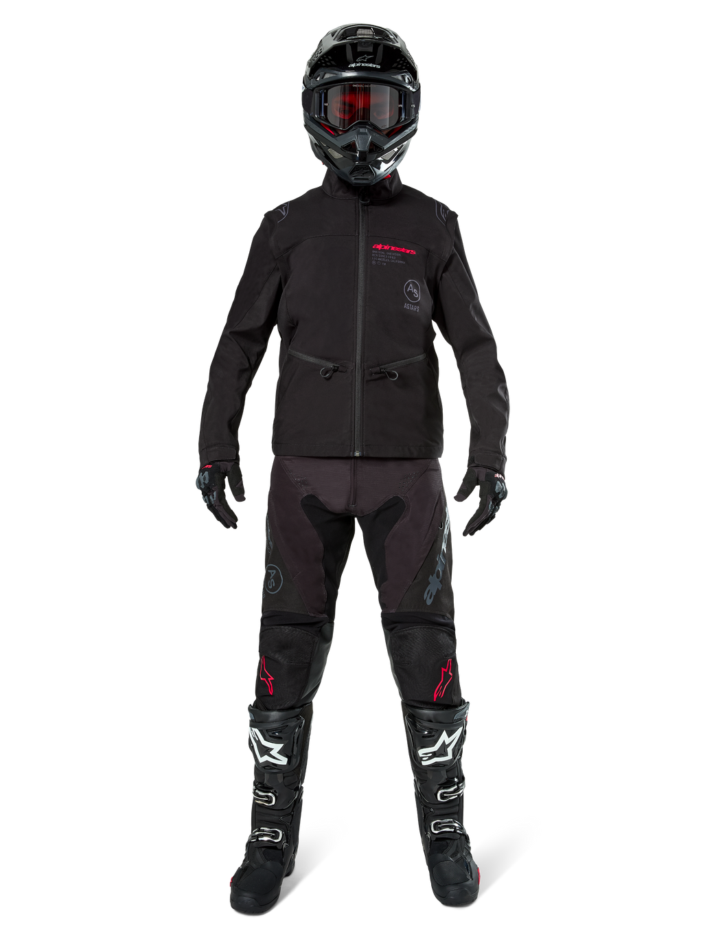 Piloto de motocross con la chaqueta Alpinestars Lite-Dura Softshell en negro con detalles rojos del logo, combinada con pantalones off-road negros a juego, casco negro y botas blancas y negras, equipamiento profesional completo de carreras de enduro.