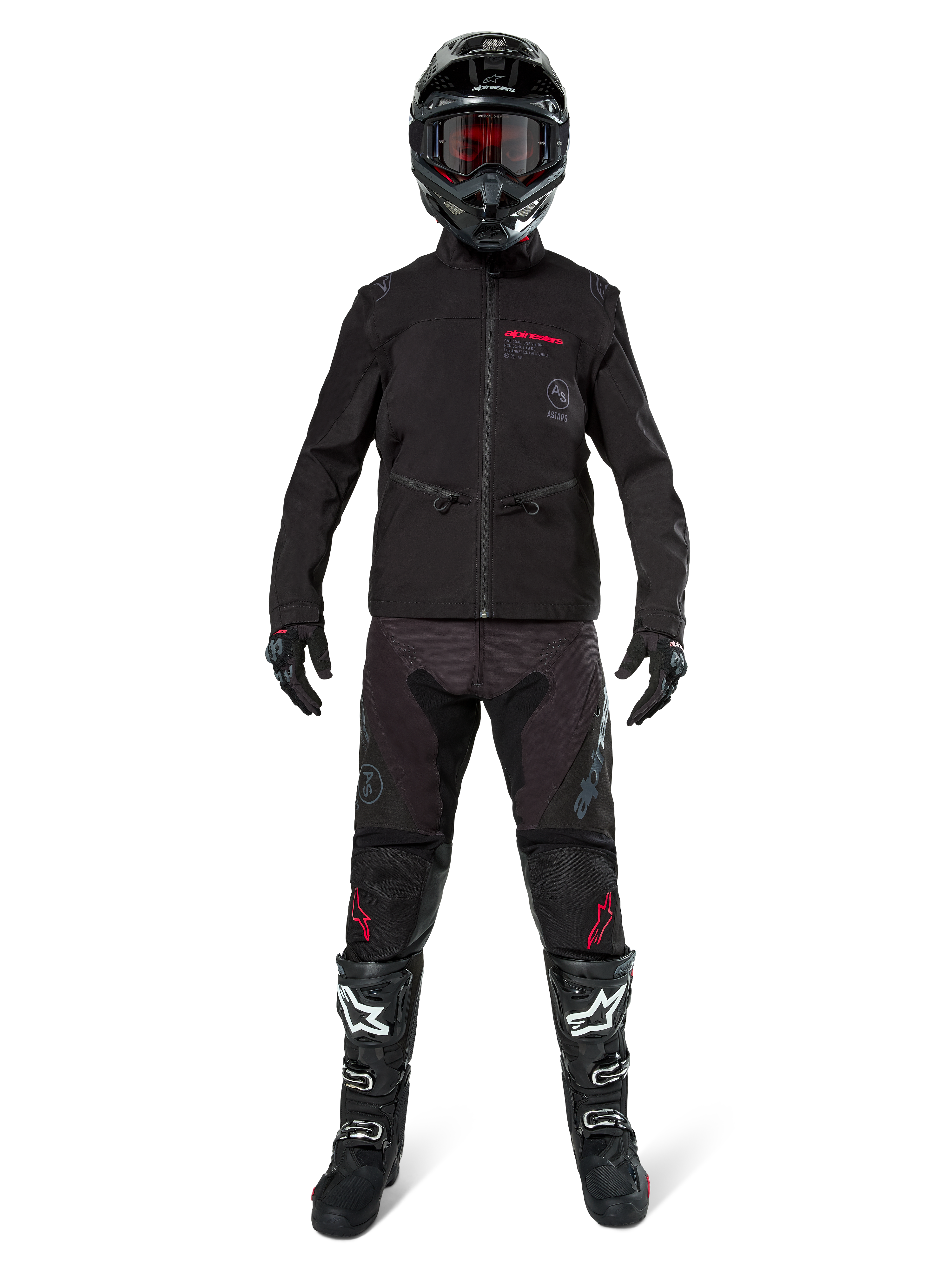 Piloto de motocross con la chaqueta Alpinestars Lite-Dura Softshell en negro con detalles rojos del logo, combinada con pantalones off-road negros a juego, casco negro y botas blancas y negras, equipamiento profesional completo de carreras de enduro.