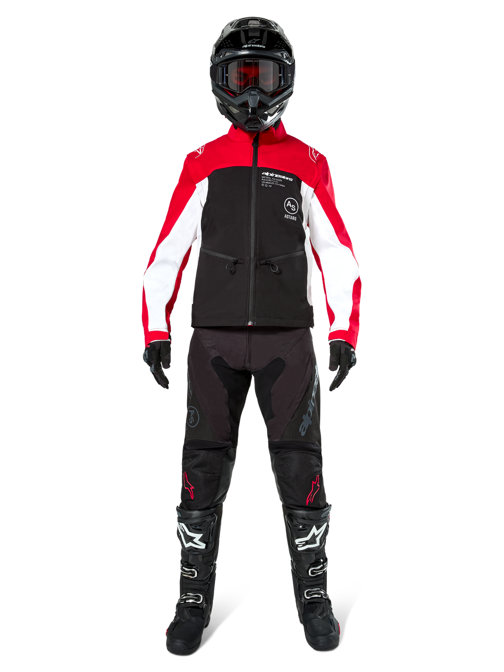 Piloto de motocross con la chaqueta softshell Alpinestars Lite-Dura en negro, rojo brillante y blanco, combinada con pantalones off-road negros, botas negras y blancas, y casco negro con gafas; equipamiento completo para competiciones de enduro
