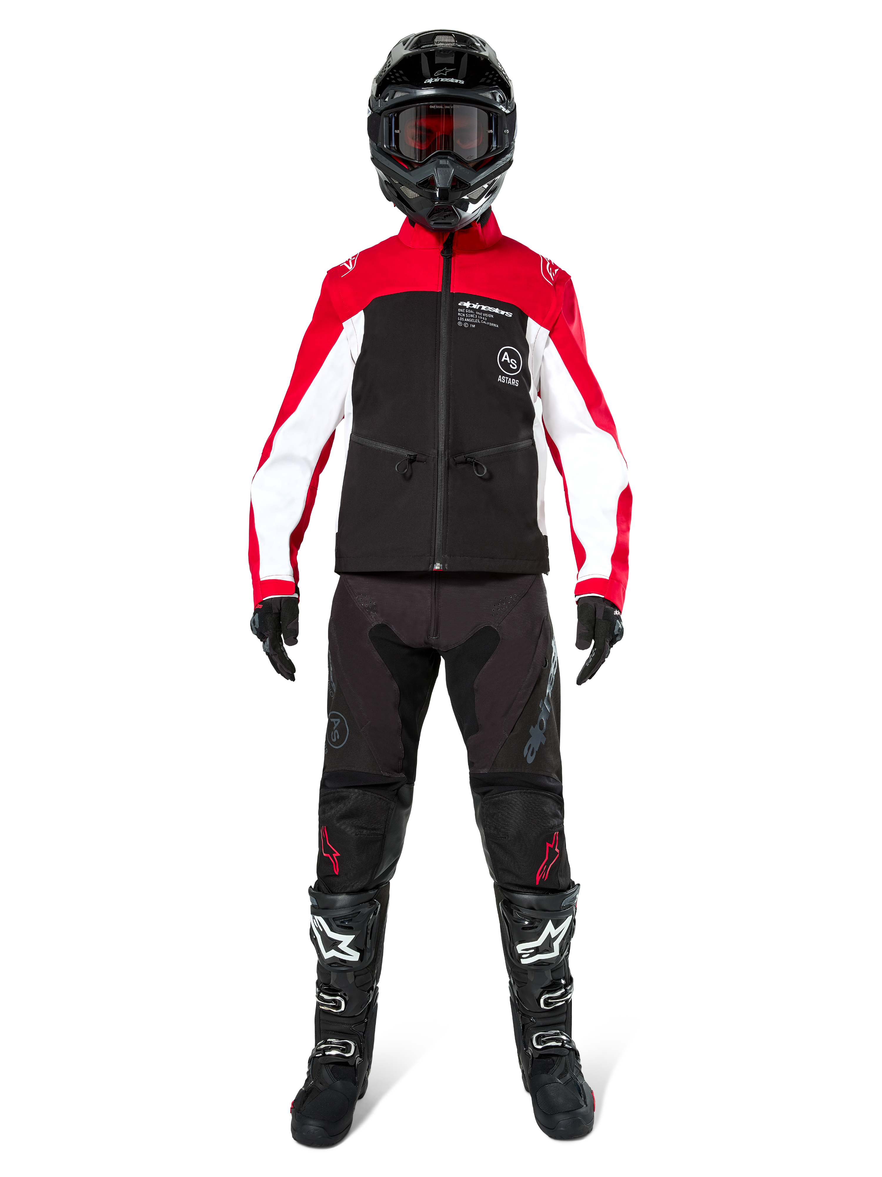 Piloto de motocross con la chaqueta softshell Alpinestars Lite-Dura en negro, rojo brillante y blanco, combinada con pantalones off-road negros, botas negras y blancas, y casco negro con gafas; equipamiento completo para competiciones de enduro