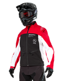 Chaqueta Softshell Alpinestars Lite-Dura, chaqueta de moto, negro, rojo brillante y blanco, vestida por un piloto con casco de motocross negro, gafas rojas y guantes, con logotipos llamativos en el pecho, diseñada para conducción off-road y enduro