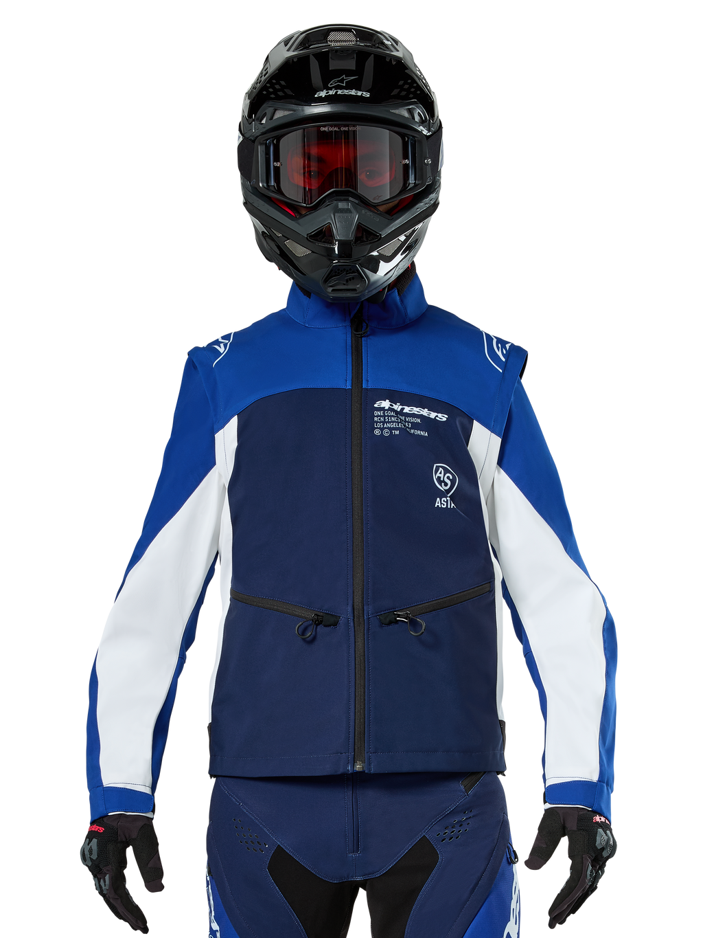 Piloto de motocross con la chaqueta Alpinestars Lite-Dura Softshell en azul marino, azul brillante y blanco, vista frontal, combinada con un casco negro y gafas con lentes rojas, con un diseño técnico cortavientos con bolsillos con cremallera y detalles en blanco para conducción de enduro off-road