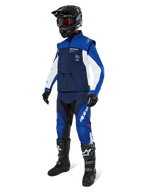 Chaqueta Softshell Alpinestars Lite-Dura, azul marino, azul brillante y blanco, combinada con pantalones off-road a juego, botas de motocross negras, casco negro con gafas y guantes negros, equipamiento de enduro completo para carreras todoterreno